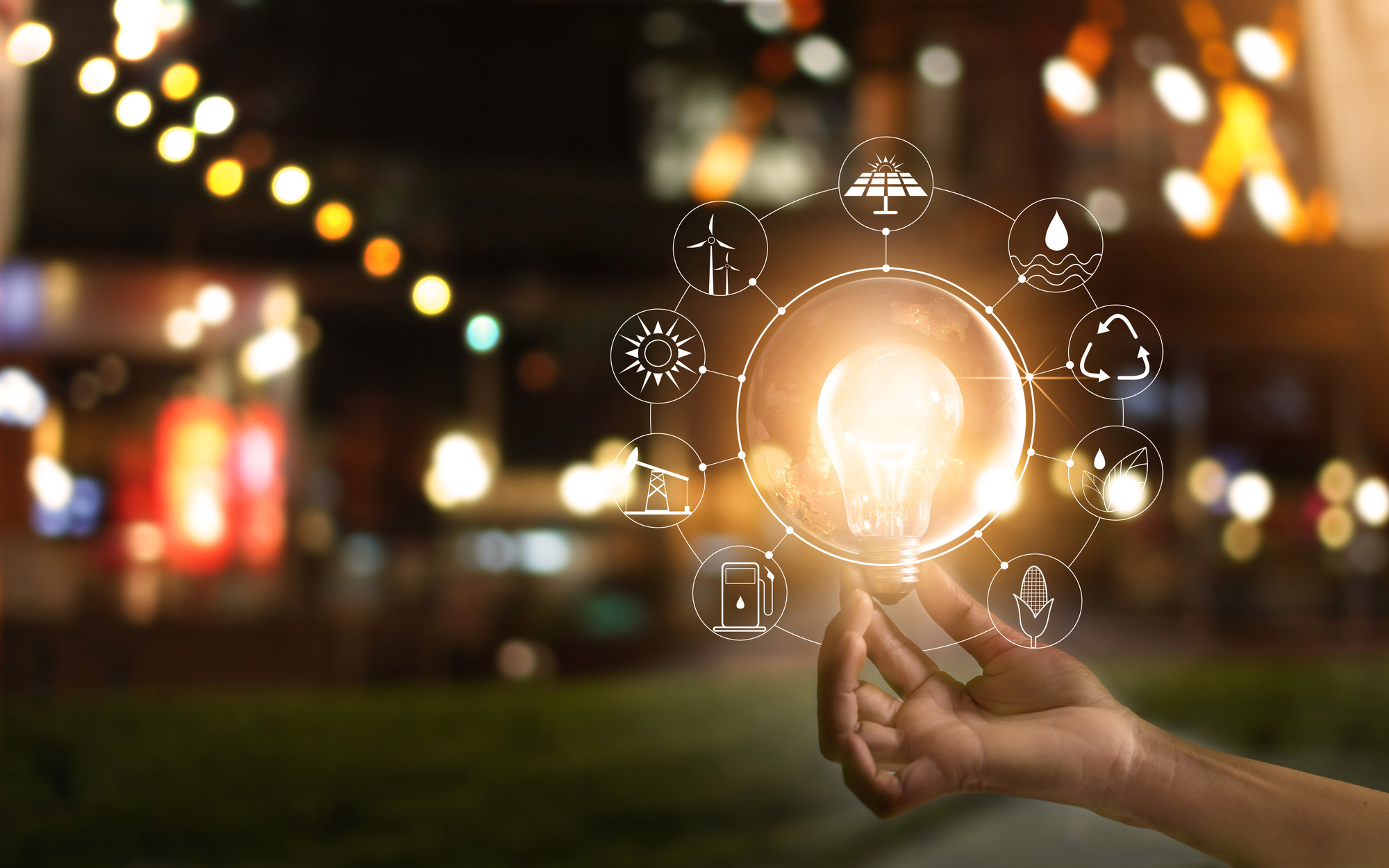 Una mano che regge una lampadina luminosa, simbolo di innovazione nell'energia pulita.