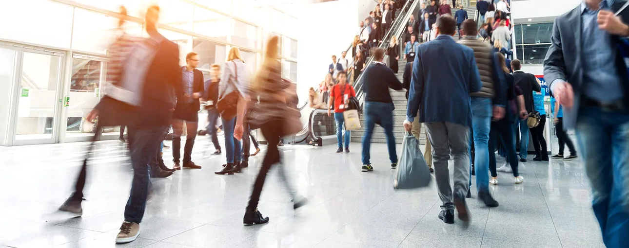 People walking through a busy exhibition hall